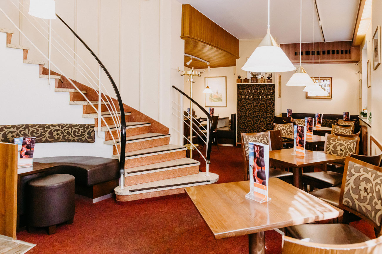 Elegantes Interieur im Café Schmidt mit geschwungener Treppe